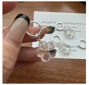 Close-up of S925 silver daisy earrings with resin flower petals and gold bead details