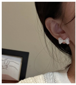 Detailed macro shot of S925 sterling silver bow earrings with textured bead surface finish