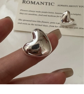 Macro detail of polished S925 sterling silver heart stud earrings with mirror finish