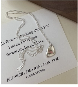 Gros plan d'un pendentif galet irrégulier en argent sterling S925 sur collier délicat