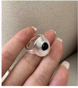 Macro shot of retro S925 silver ring with black agate inlay and spiral textured teardrop design