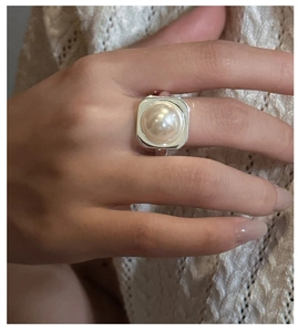 Detail view of a minimalist S925 silver ring featuring a round pearl on a square setting
