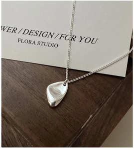 Vue macro du collier S925 argent avec pendentif irrégulier sur boîte en bois