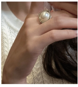 Close-up of a vintage S925 silver ring featuring a large white round pearl on a model hand