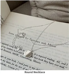 Detailed view of S925 sterling silver minimalist round necklace on an open book