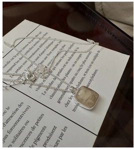 Close-up of S925 sterling silver stamp on minimalist square pendant necklace