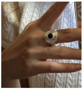 Macro shot of silver ring featuring radial texture and a black onyx stone inlay