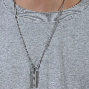 Collana minimalista da uomo in argento con pendente a cilindro industriale indossata