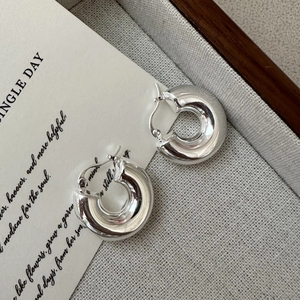 Créoles épaisses en argent sterling S925 poli présentées sur un fond en tissu texturé
