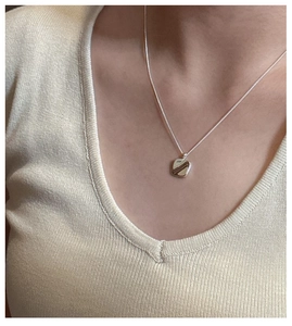 Detail view of minimalist S925 sterling silver square pendant necklace on a model