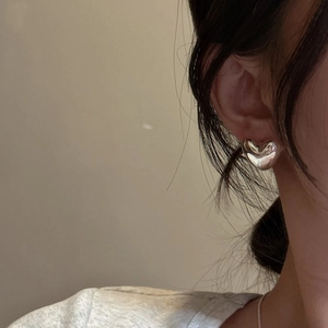Minimalist S925 sterling silver heart-shaped stud earrings worn by a female model