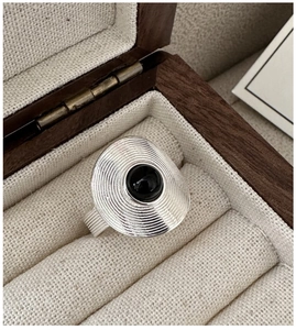 Macro shot of S925 silver ring featuring concentric textures and a black onyx gemstone