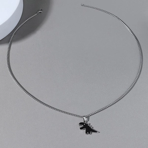 Dettaglio di una catena in acciaio inossidabile con ciondolo a dinosauro nero e chiusura