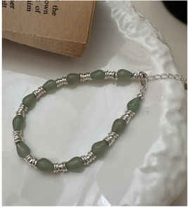 Détail d'un bracelet vintage avec pierres gouttes vertes et fermoir mousqueton argent