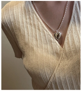 Close-up of S925 sterling silver hollow heart pendant necklace worn on a model's neck