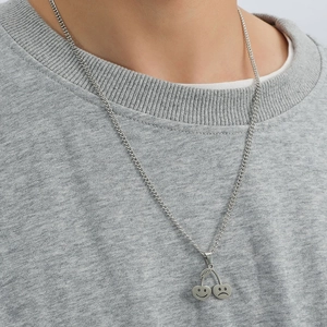 Collier hip hop en acier inoxydable avec pendentif cerise smiley porté sur un sweat gris