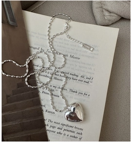 Detailed close-up of S925 sterling silver heart pendant with AG925 hallmark tag