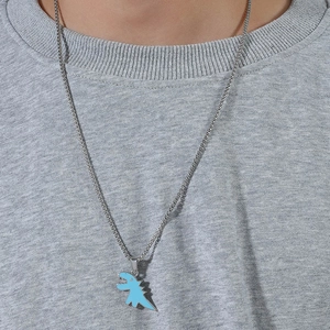 Dettaglio della collana con dinosauro blu in acciaio inossidabile su felpa grigia