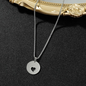 Macro view of a circular hollow heart pendant on a stainless steel box chain necklace