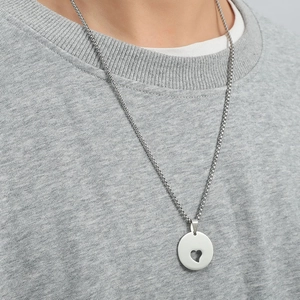 Minimalist stainless steel necklace with hollow heart pendant on grey sweatshirt background