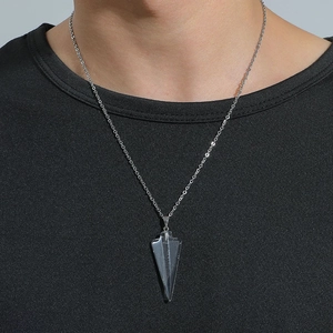 Gros plan d'une chaîne argentée minimaliste avec pendentif triangulaire transparent sur mannequin