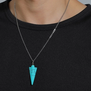 Détail d'un pendentif triangle en turquoise avec chaîne argentée sur t-shirt noir
