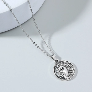 Retro stainless steel necklace featuring a sun and moon face pendant on a silver link chain