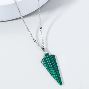 Gros plan du pendentif triangle en malachite verte avec chaîne argentée sur blanc