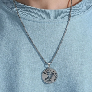 Hollow earth pendant necklace in silver stainless steel on a blue textured shirt