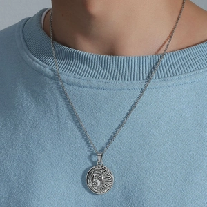 Vintage sun and moon face pendant necklace in silver finish on a light blue sweater