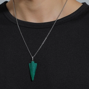 Gros plan du pendentif triangle en malachite verte sur chaîne argentée portée sur noir