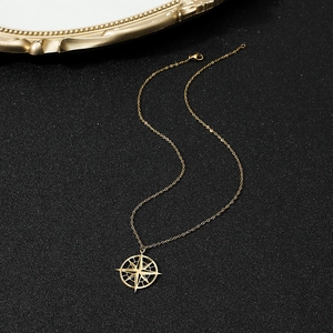 Detailed view of golden compass star pendant necklace on a textured black background