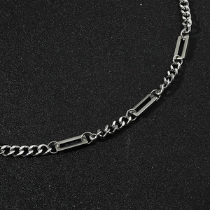 Collana d'argento da uomo con maglie rettangolari e catena barbazzale su sabbia nera