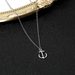 Silver nautical anchor pendant necklace with cross chain on a minimalist dark background