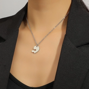 Collier minimaliste en argent avec pendentif puzzle coeur porté sur un costume
