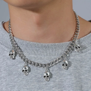 Collier punk argenté avec cinq pendentifs crânes sur chaîne cubaine porté par un homme