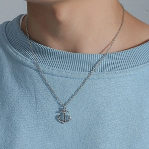 Silver nautical anchor pendant necklace for men worn on a light blue sweatshirt
