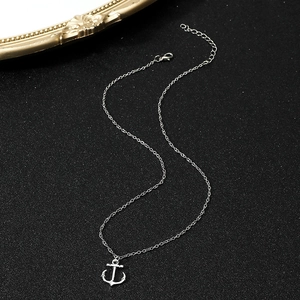 Close-up of silver anchor pendant necklace with fine chain on elegant black background