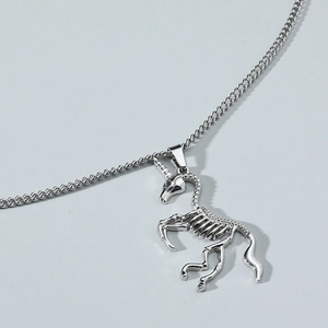 Silver unicorn skull skeleton pendant on a flat lay curb chain stainless steel necklace
