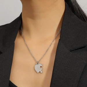 Collier avec pendentif cœur puzzle en acier inoxydable argenté porté par un mannequin