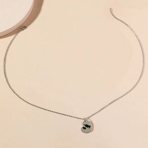 Collier cœur argenté élégant avec silhouette mère-enfant sur fond beige neutre