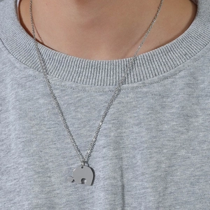 Collier de couple en acier titane avec pendentif puzzle éléphant sur sweat gris