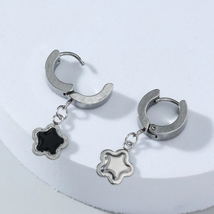 Dettaglio di orecchini a cerchio con stella in argento, smalto nero e pendenti in madreperla