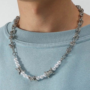 Unisex pearl and metallic barbed wire necklace shown on a light blue sweater