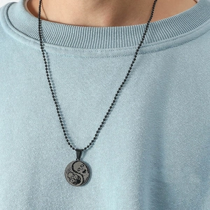 Close-up of black matte stainless steel necklace with Yin Yang skull pendant design