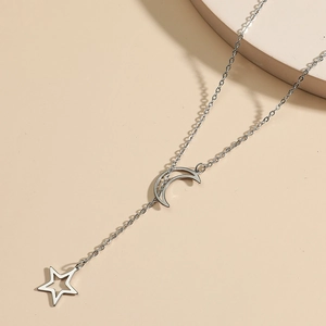 Minimalist Y-shaped necklace with silver crescent moon and hollow star pendant on beige surface