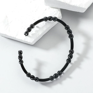 Detail of minimalist black braided headband with non-slip teeth and glossy finish