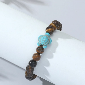 Macro shot of turquoise sea turtle bead and tiger eye stones on an elastic bracelet