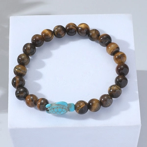 Detailed view of beaded bracelet with brown tiger eye stones and a blue turtle charm