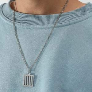 Gros plan du pendentif hip hop avec cage rectangulaire évidée sur une chaîne en acier